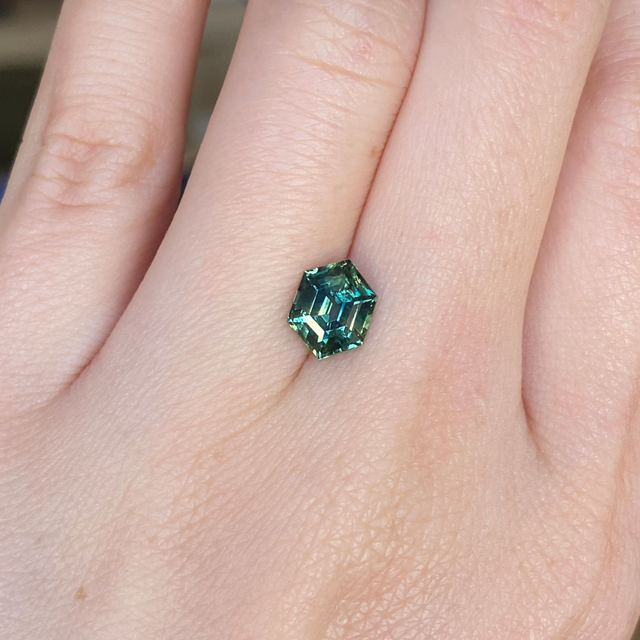 hexagon cut Sapphire on hand for scale reference