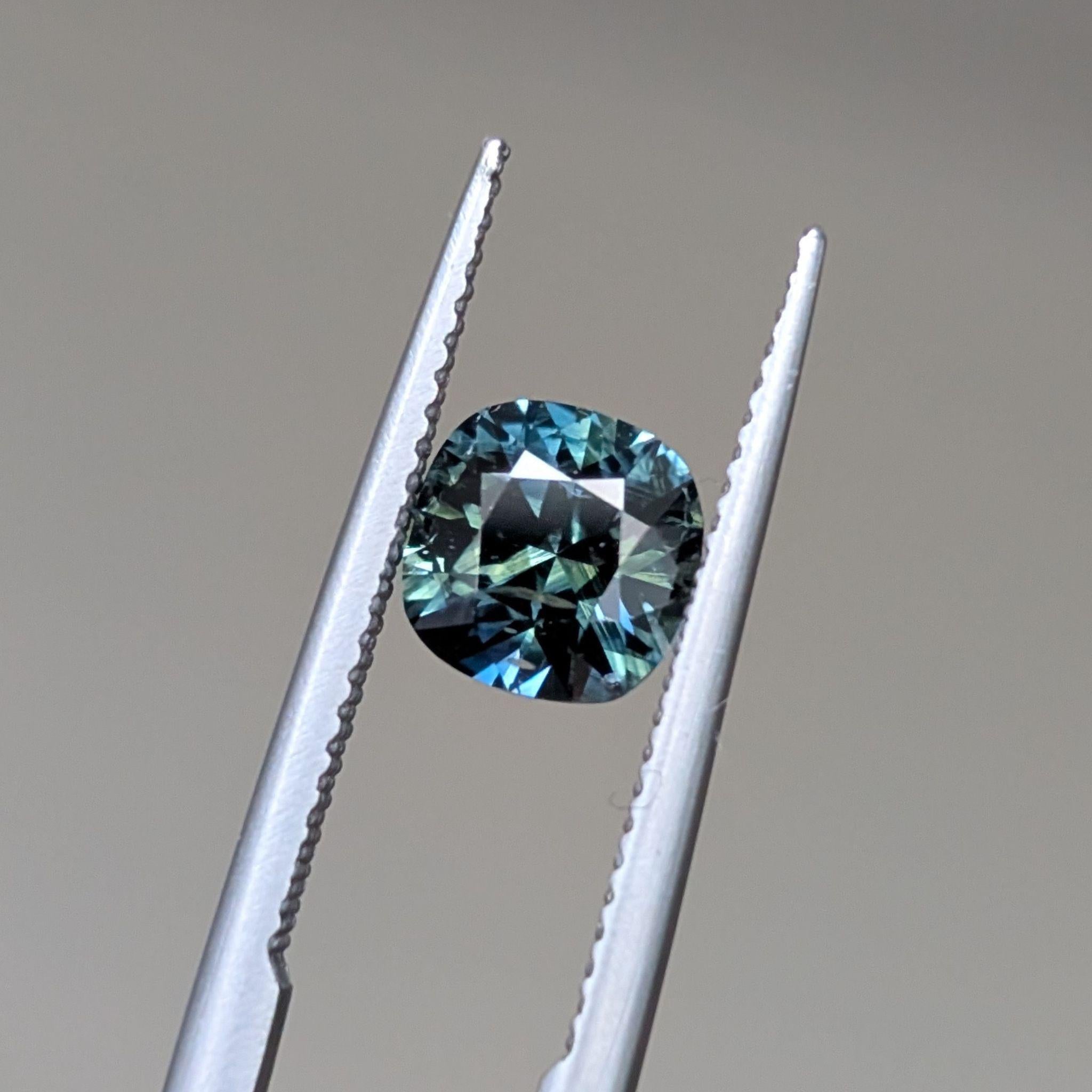 Sparkling sapphire at angle – Cushion cut sapphire reflecting light with green-blue flashes