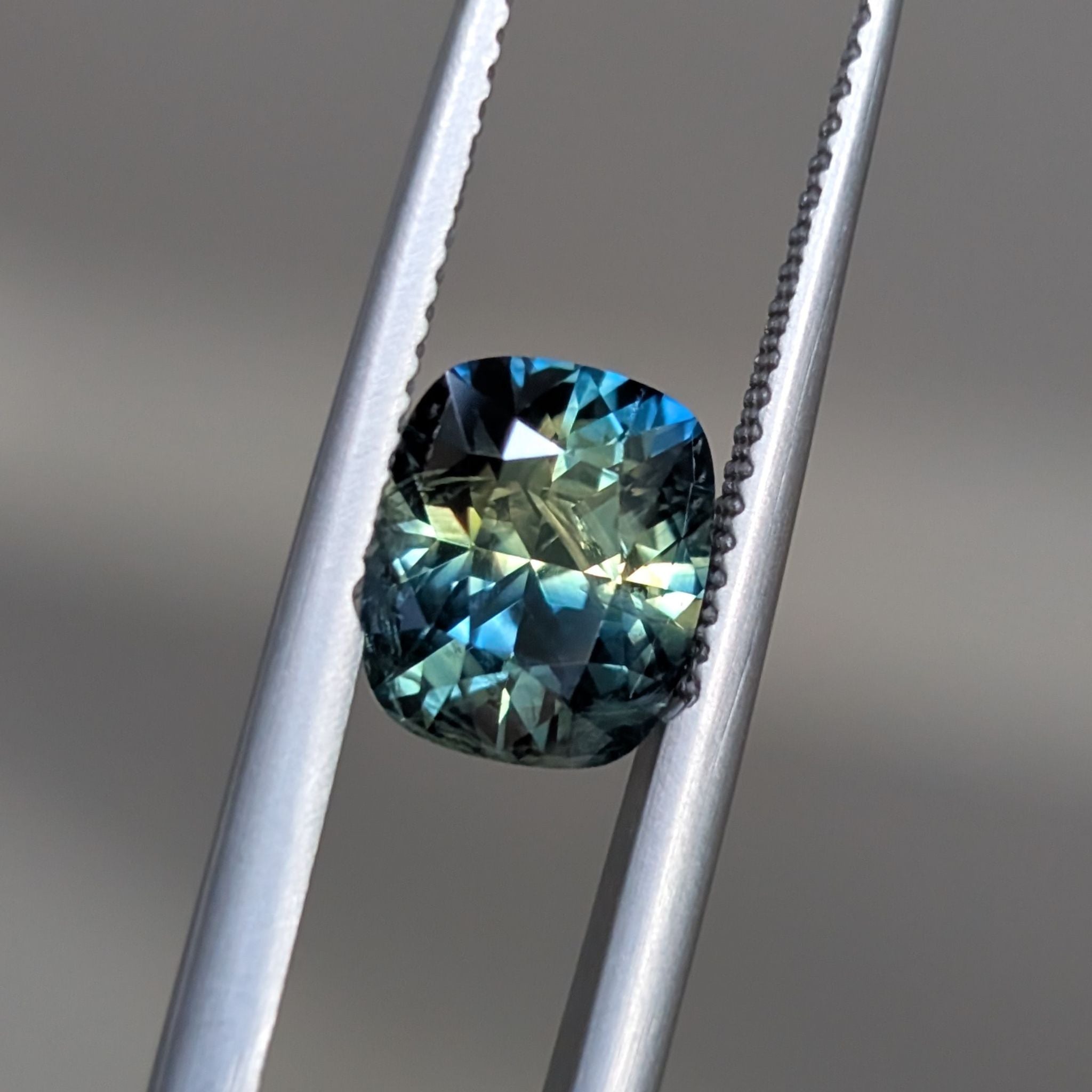 right studio shot of parti sapphire – Clean cut cushion shape showing colour split across the stone