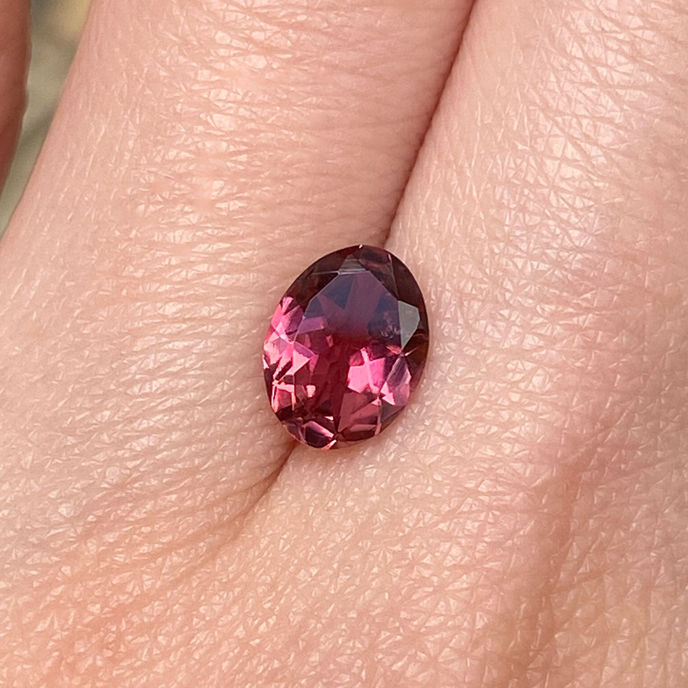 Oval tourmaline gemstone with orange pink hues
