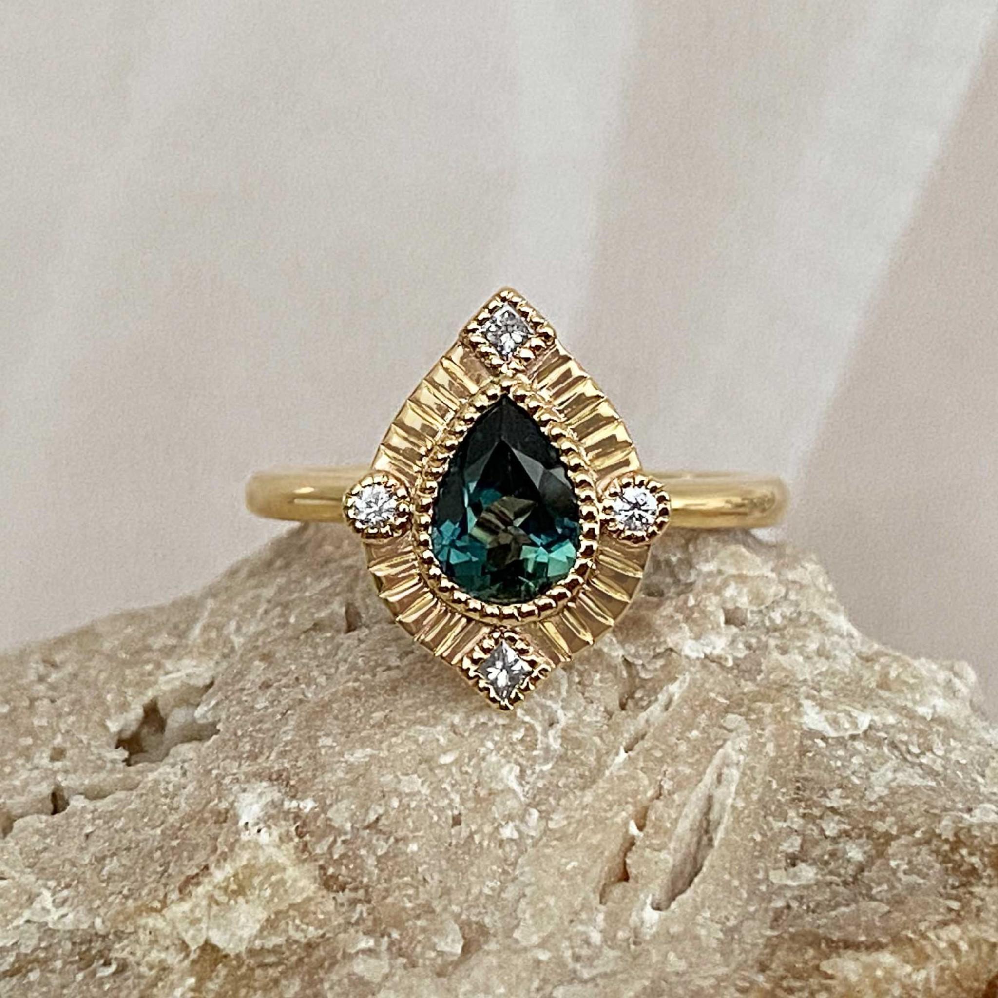 Pear shaped untraditional halo engagement ring with diamonds