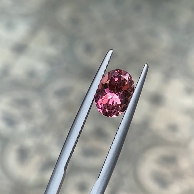Oval cut pink tourmaline gemstone showing soft rose tones