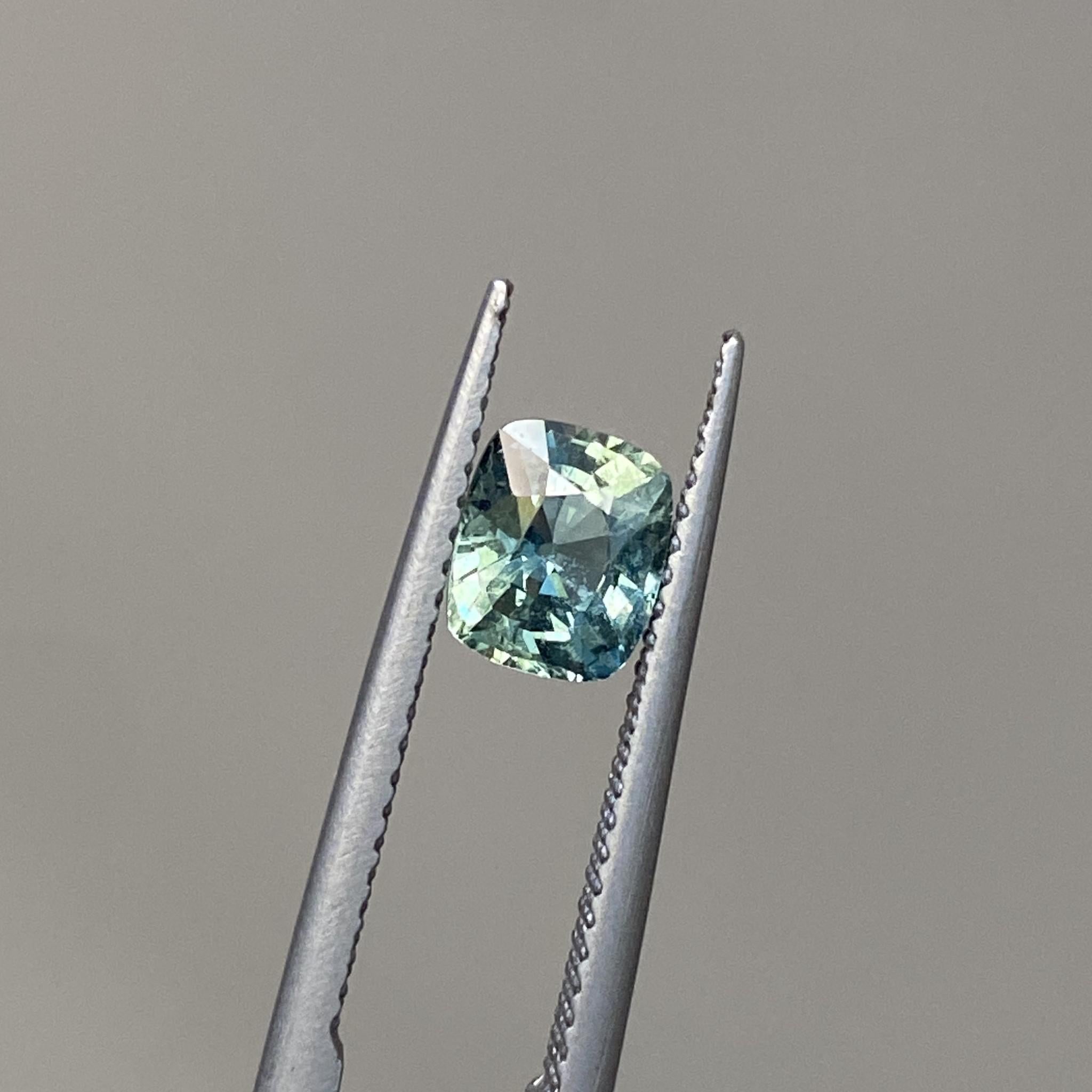Mint Tea cushion-cut sapphire reflecting its delicate teal tones under light