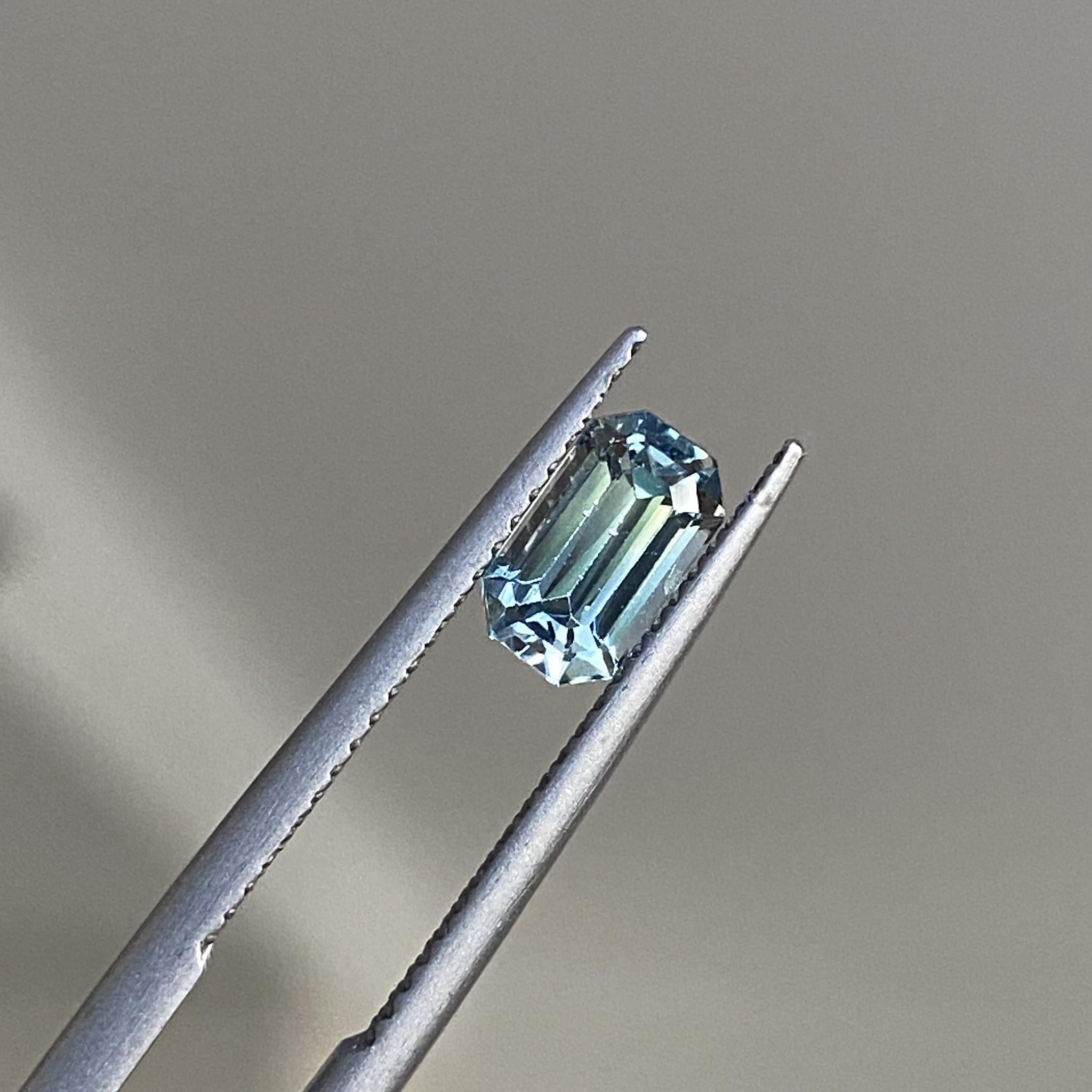 Ice blue sapphire under light, displaying its elegant transparency and vivid facets.