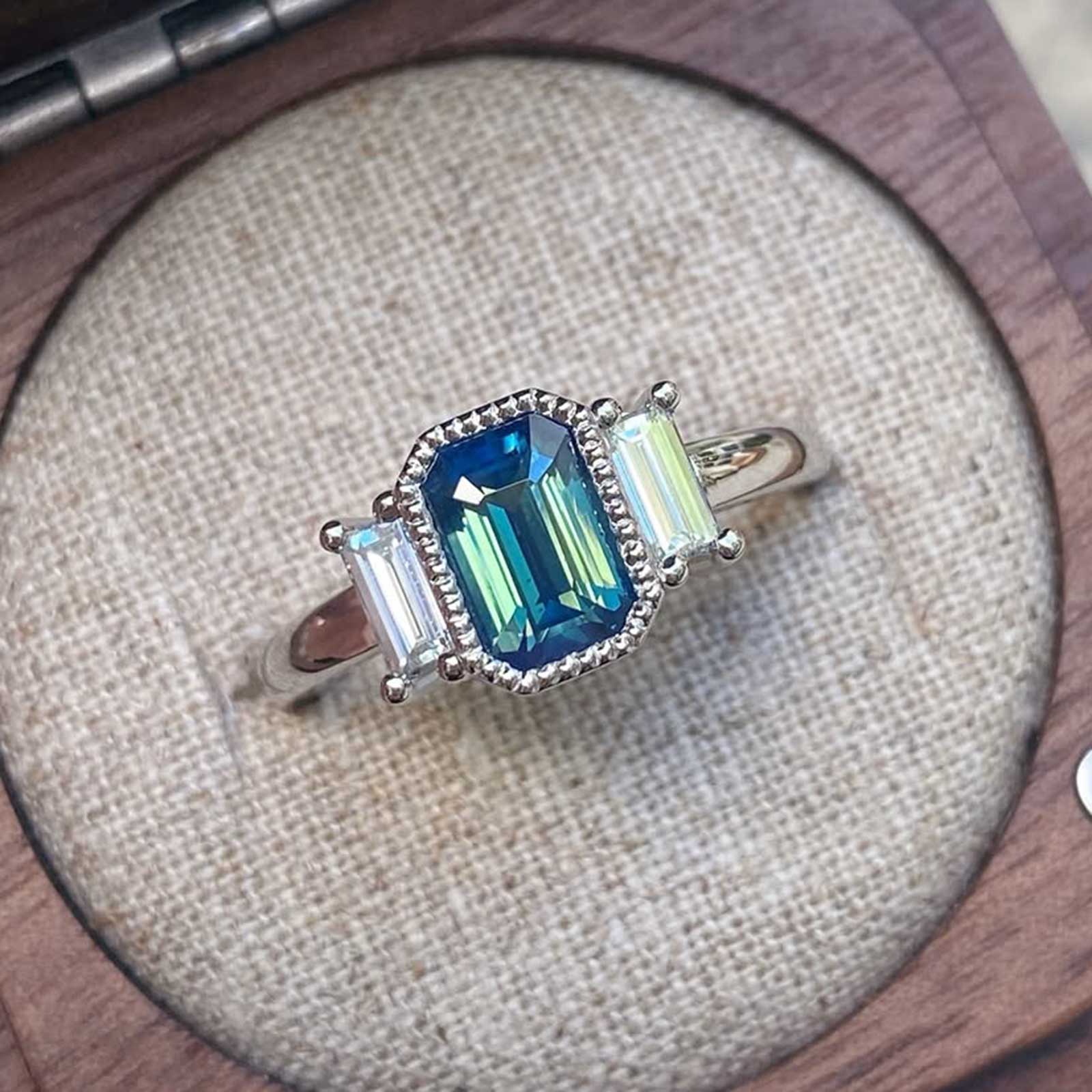 Art deco teal bicolour emerald cut sapphire ring with baguette diamonds