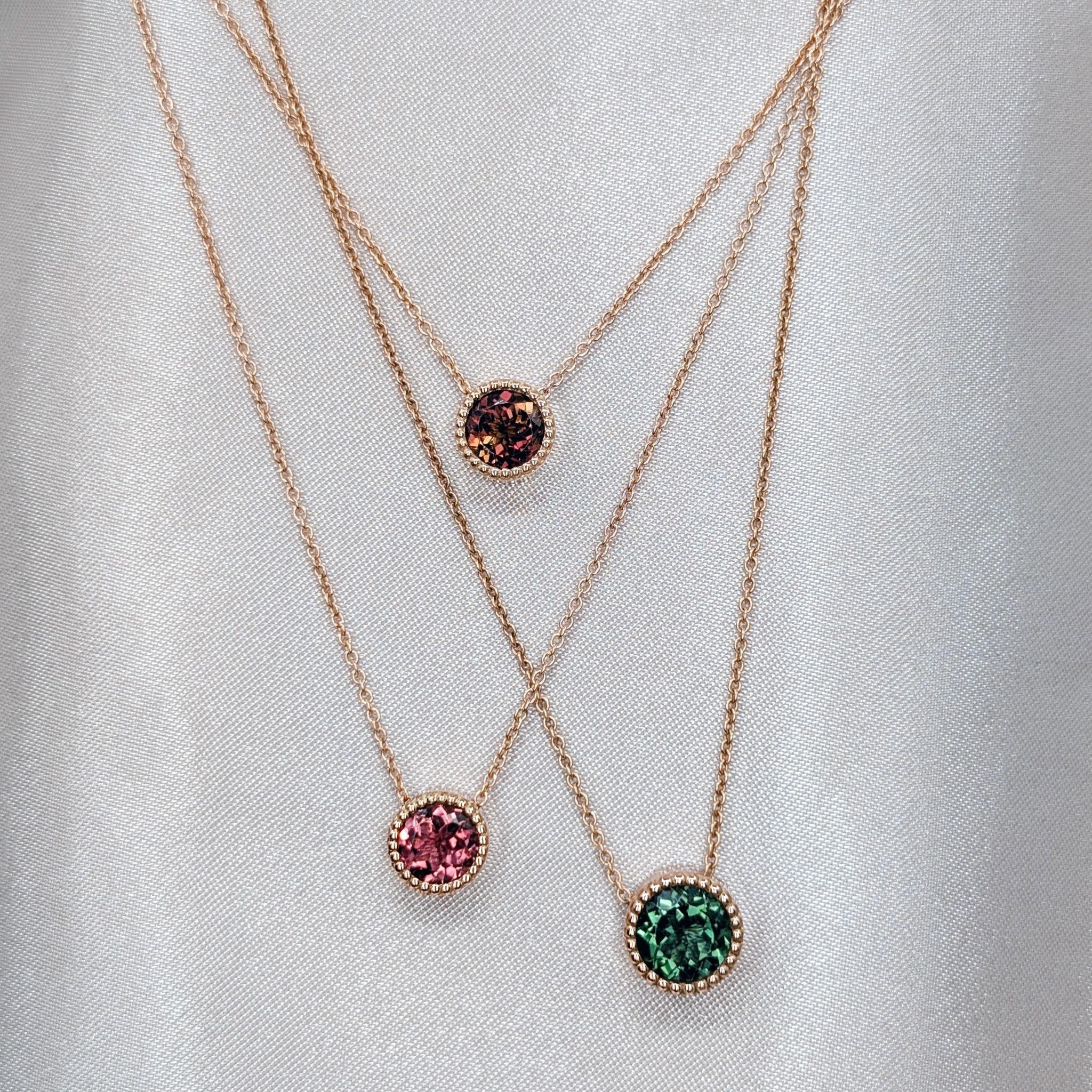 layered gold necklaces with green pink and  bicolour tourmalines