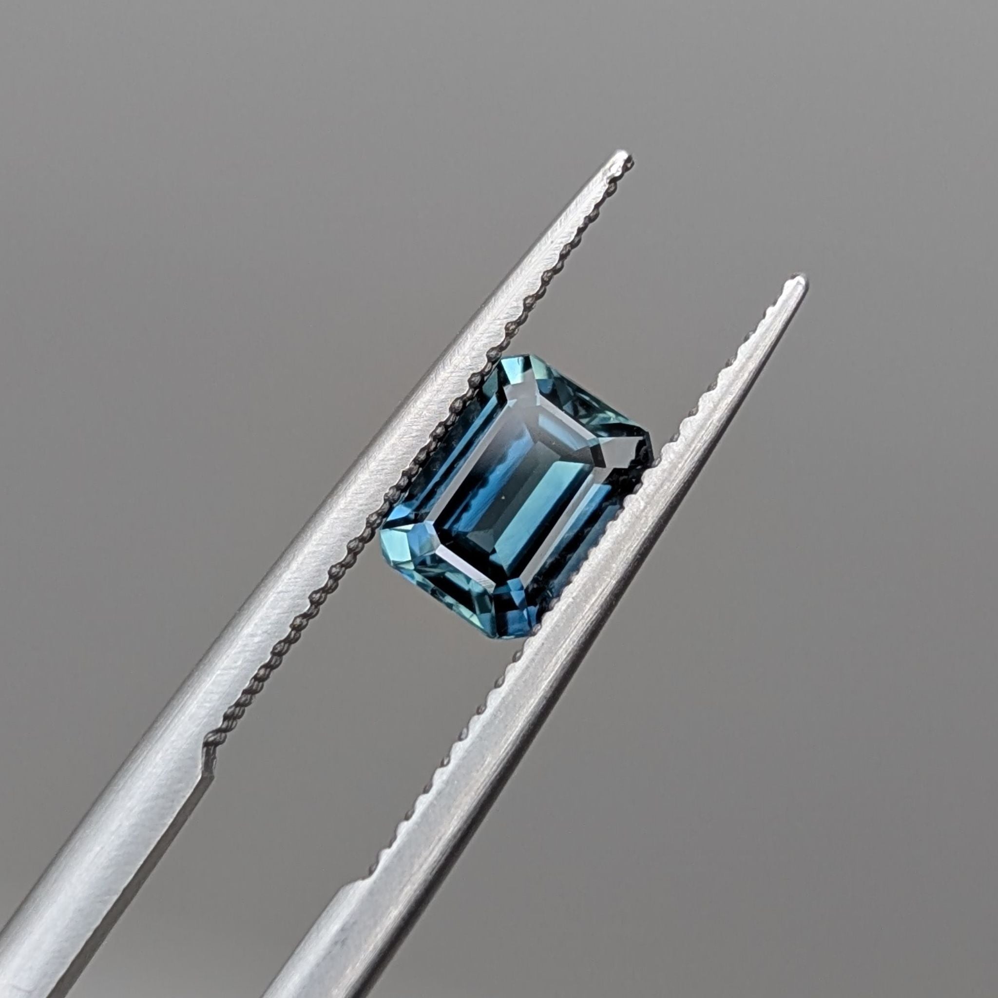 a blue moody emerald cut sapphire with facets