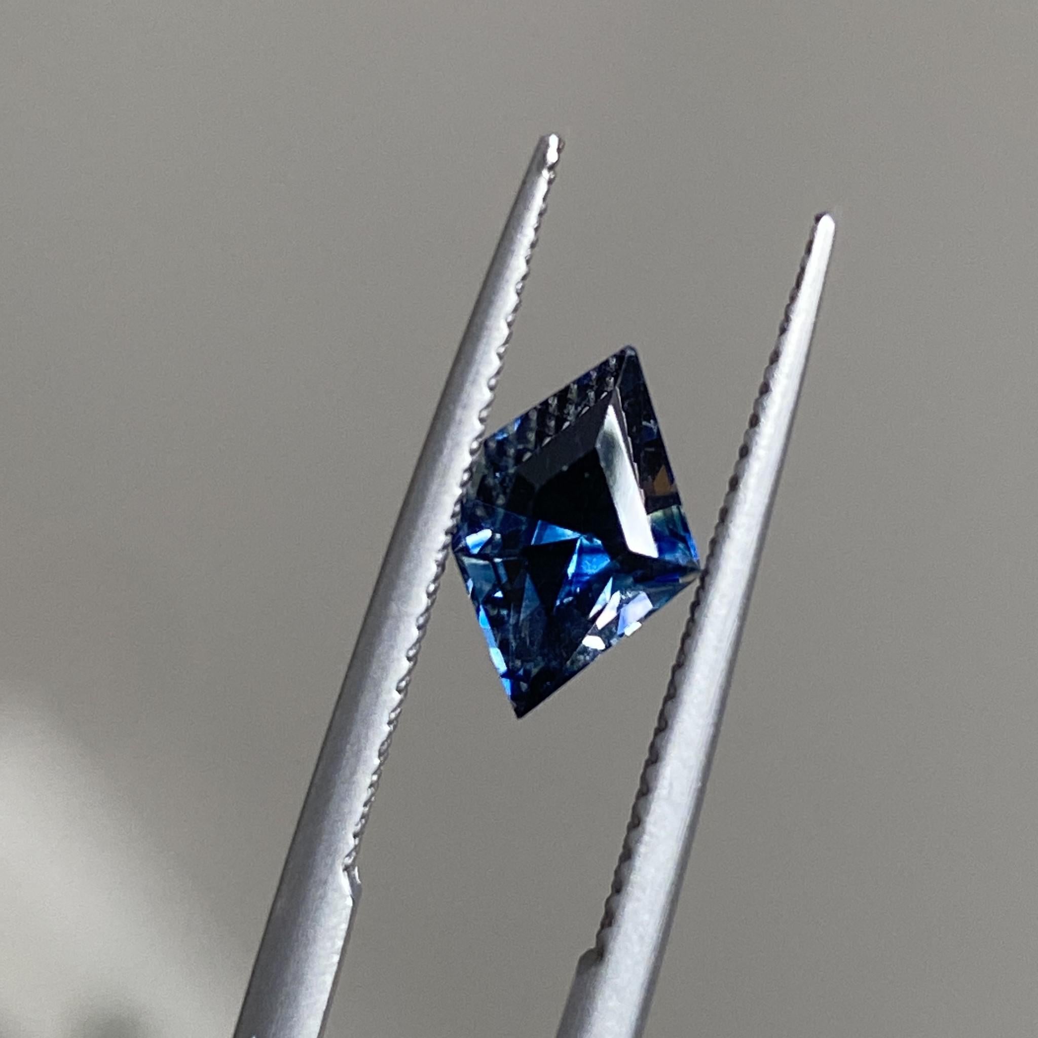 Geometric freeform sapphire tilted to reveal its vivid blue hues and distinctive contours.