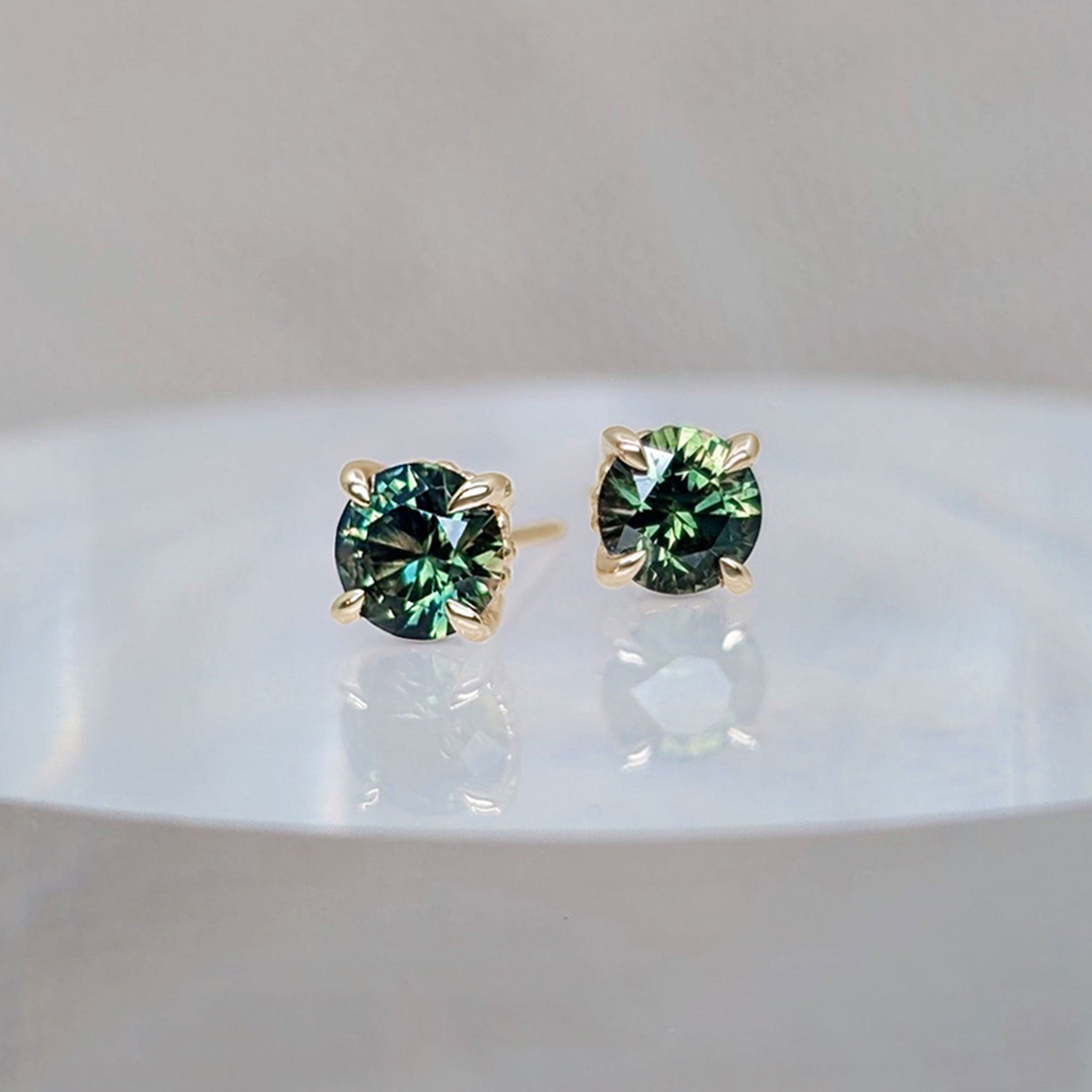 Green sapphire earring studs in gold four-claw settings