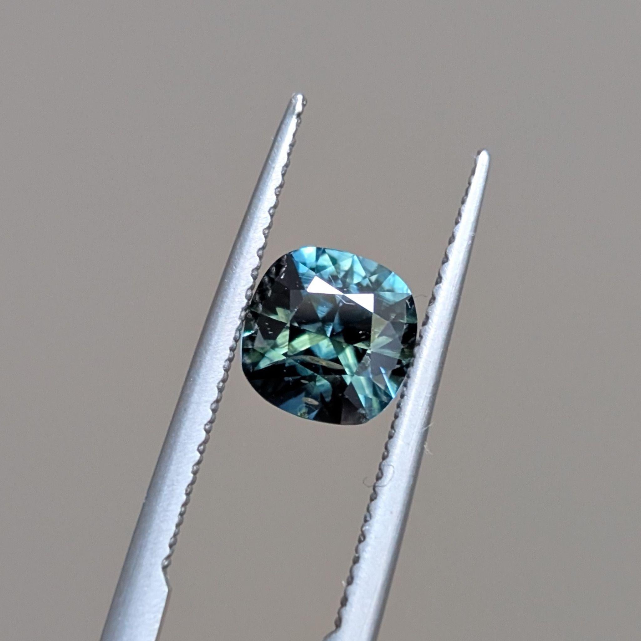 Top view of High Tide gem – Symmetrical cushion sapphire showing sea-blue and teal zoning under direct light