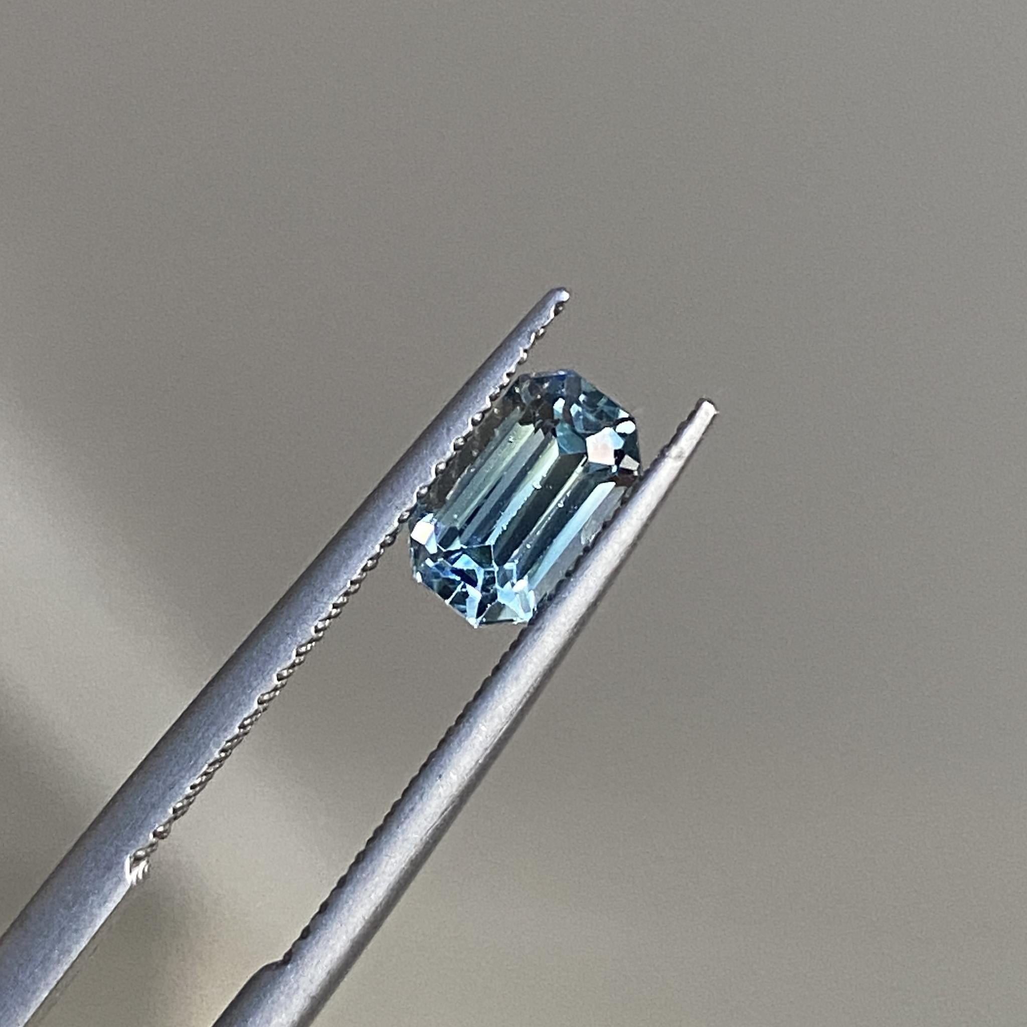 Close-up of the long emerald cut sapphire, focusing on its crisp edges and icy brilliance.