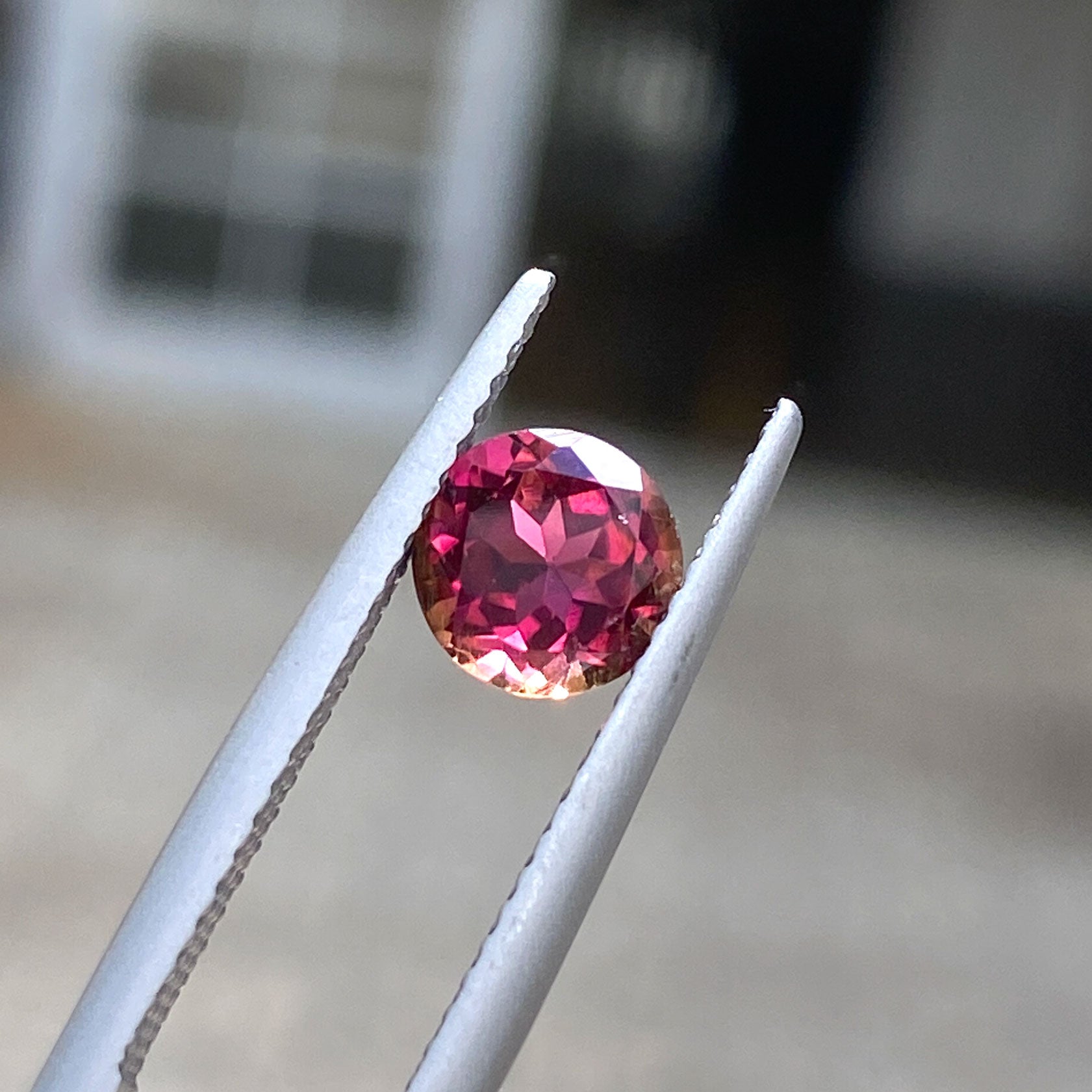 Round burgundy tourmaline gemstone with warm orange undertones