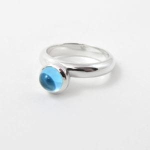 Blue topaz cabochon ring featuring a domed birthstone