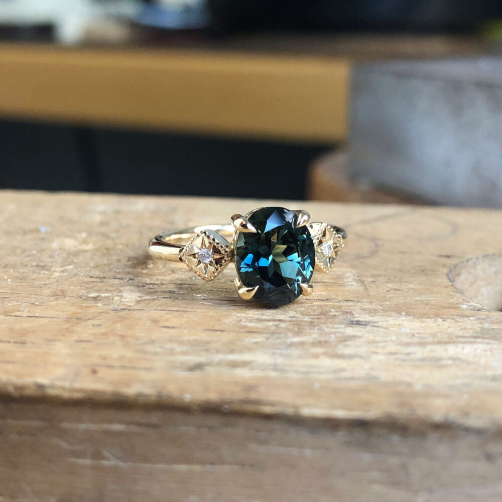 Australian teal sapphire ring with star-set lab created diamonds
