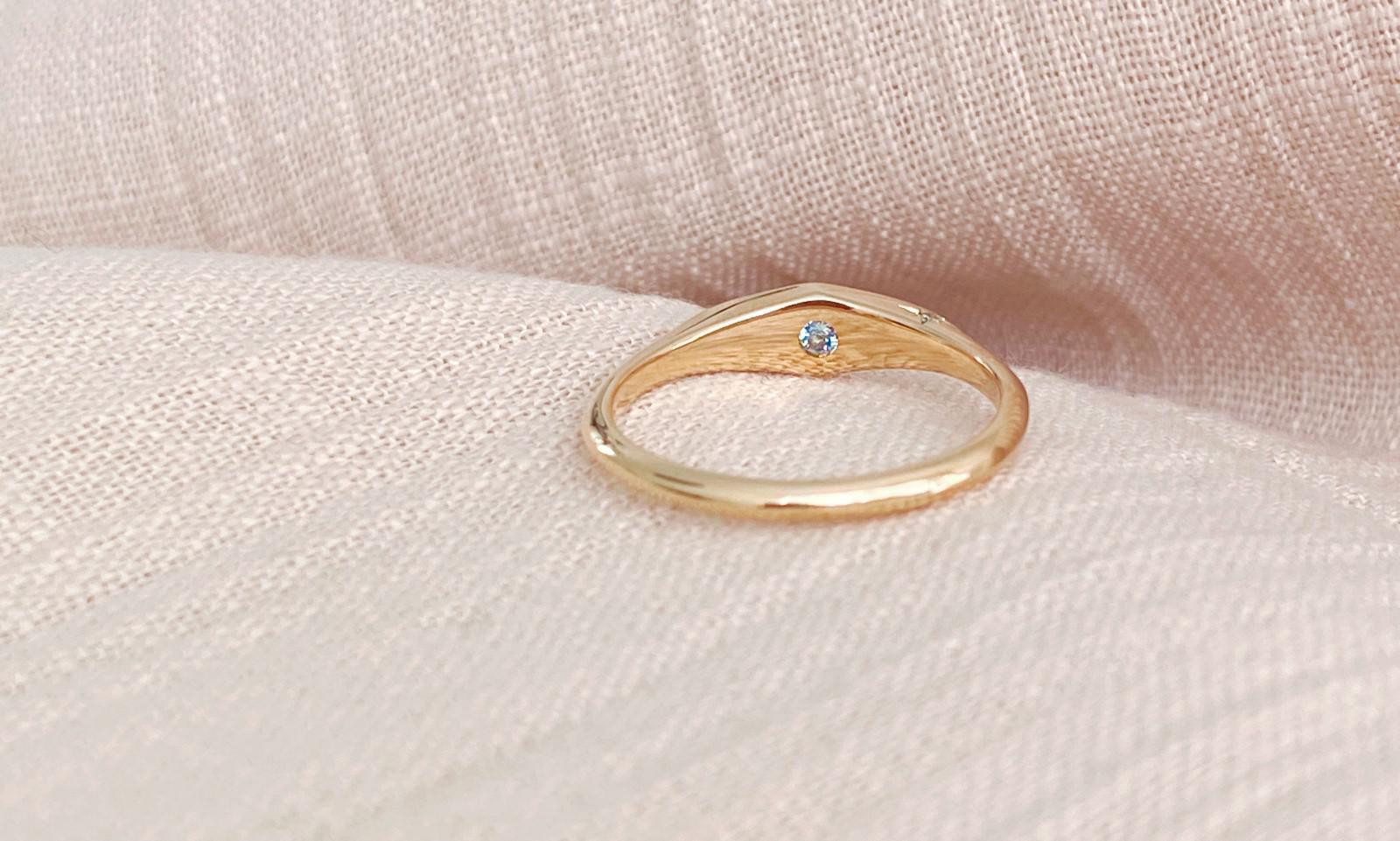 Gold signet engagement ring details with blue topaz