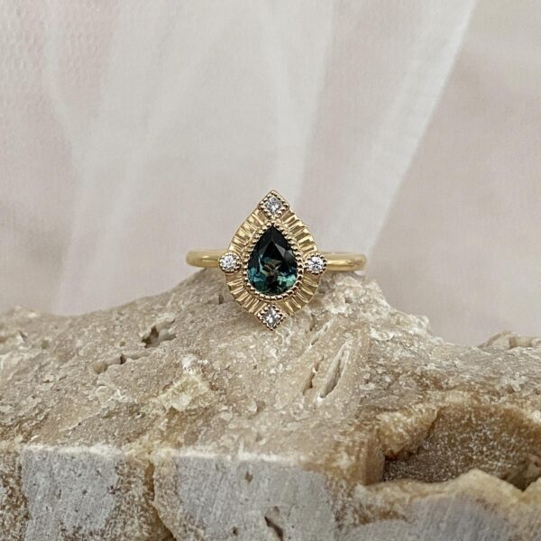 Pear shaped untraditional halo engagement ring with diamonds