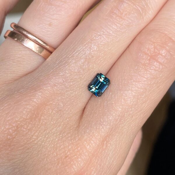 Parti teal and yellow Australian sapphire displayed on hand